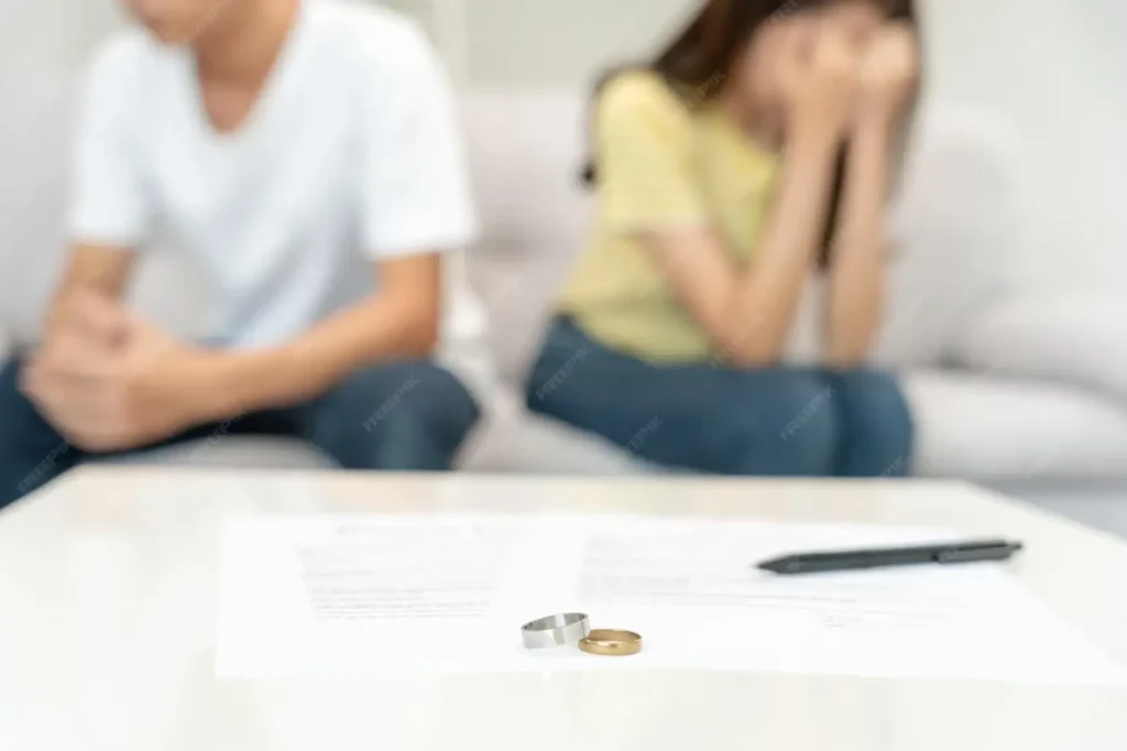 Couple in emotional distress discussing divorce, with wedding rings and legal documents on table, representing family law appeals in Humble, Texas.