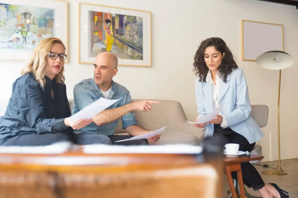 Three individuals discussing legal documents in a modern office setting, emphasizing collaboration in family law appeals in Lancaster, TX.