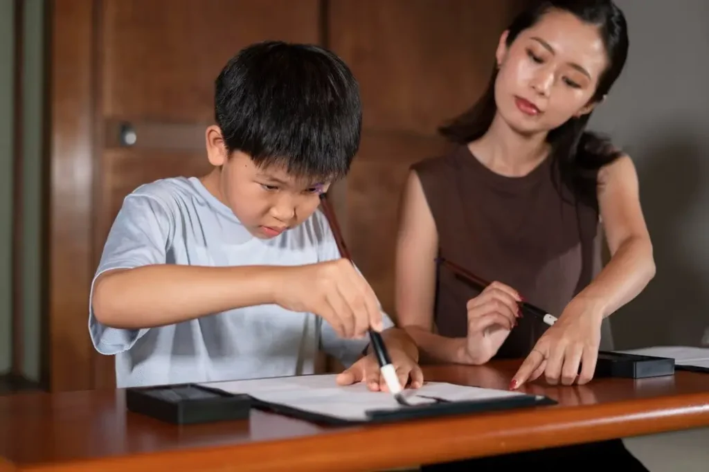 Child and adult engaged in focused writing activity at a table, emphasizing family collaboration and support in legal matters.