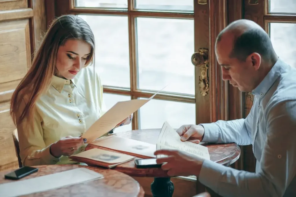 Red River Cultural District Couple reviewing menus at a table in a cozy restaurant, reflecting on family law appeal discussions in the Red River Cultural District.