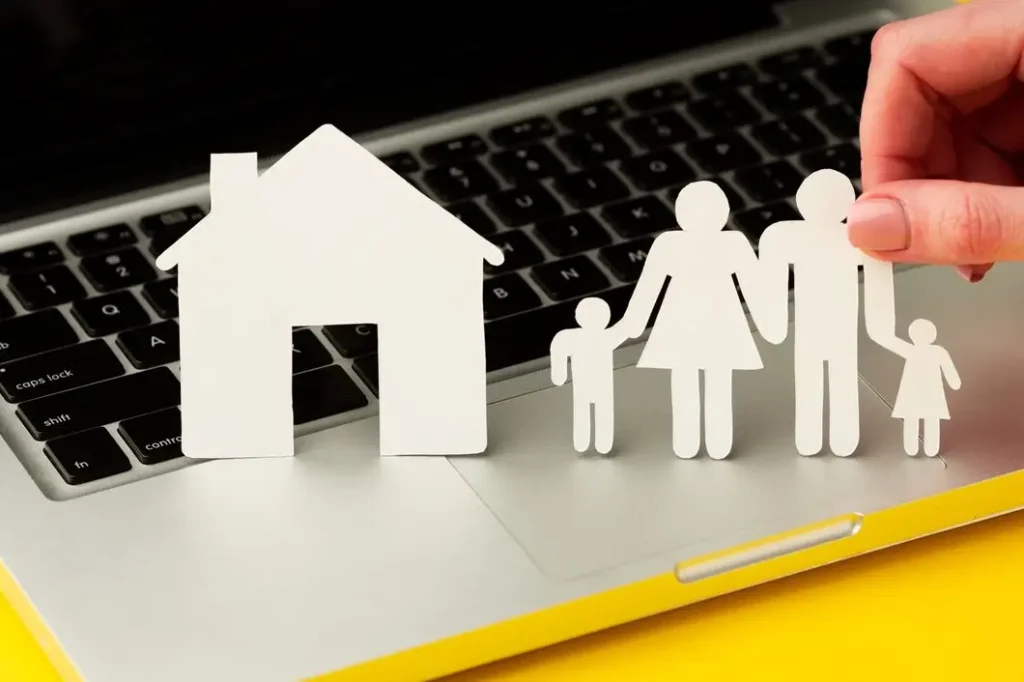 Paper cutouts of a family and a house on a laptop keyboard, symbolizing family law and appellate services in Scofield Farms.