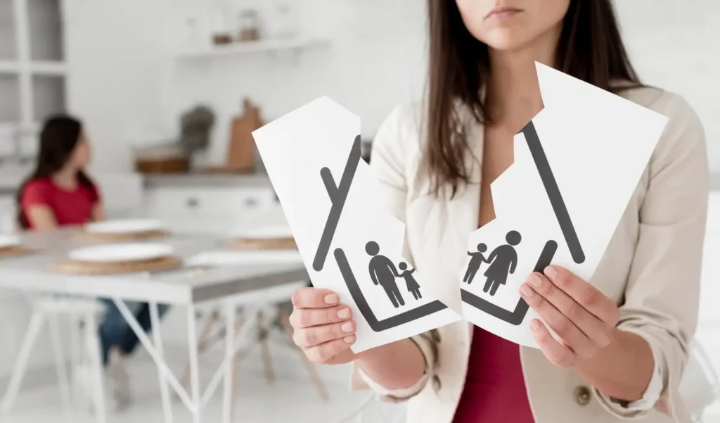 Woman holding torn paper depicting a broken family symbol, representing family law appeals and custody issues, with a child in the background illustrating the emotional impact of family court decisions.