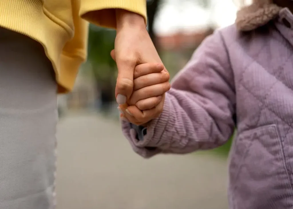 Adult and child holding hands, symbolizing family support and connection, relevant to family law appeals in Village at Western Oaks.