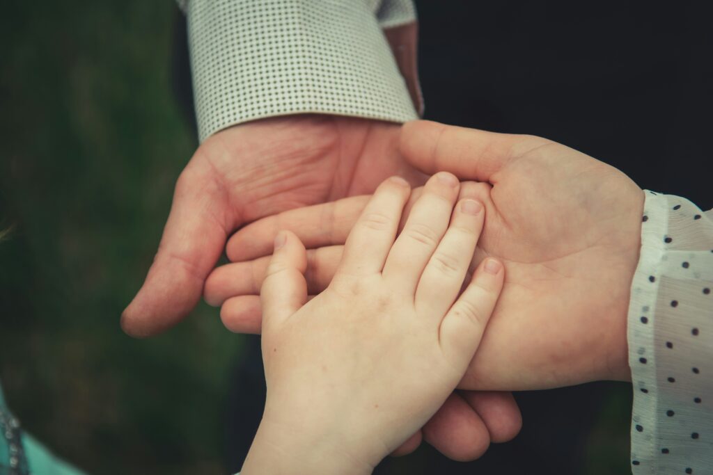 Hands of an adult and a child clasped together, symbolizing family connection and support, relevant to family law appeals in Converse, Texas.