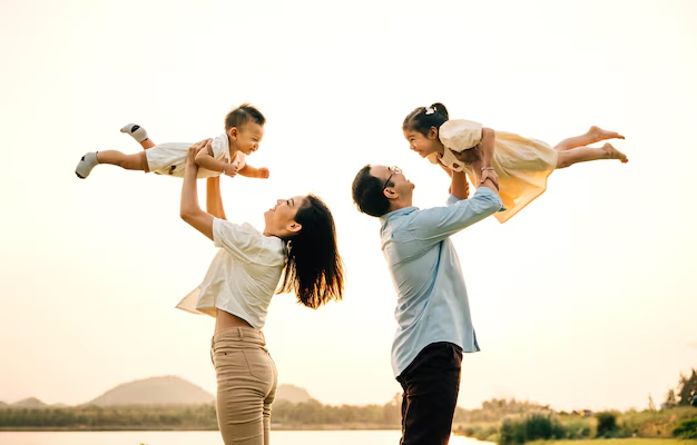 Family enjoying time outdoors, parents lifting children against a sunset backdrop, symbolizing family unity and support in legal matters related to family law appeals.