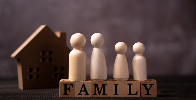 Wooden family figurines representing family unity and support, with blocks spelling "FAMILY" and a house silhouette in the background, symbolizing family law and custody matters in Sandy Oaks.