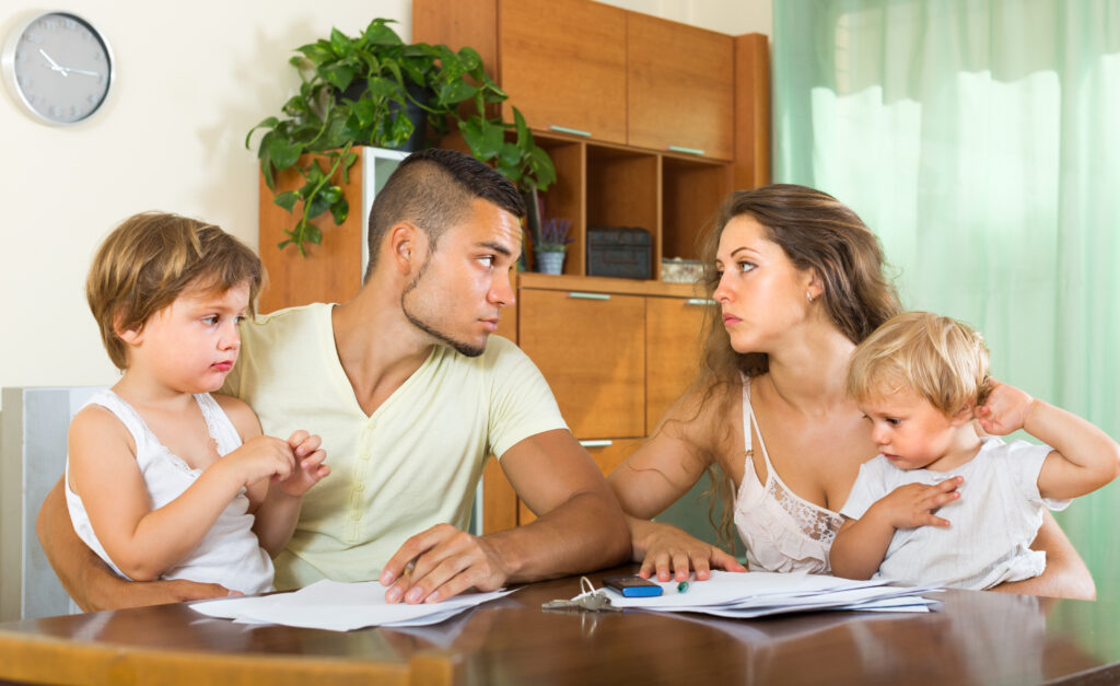 Parents in a tense discussion with children at a table, highlighting family conflict related to custody and support issues in family law appeals.